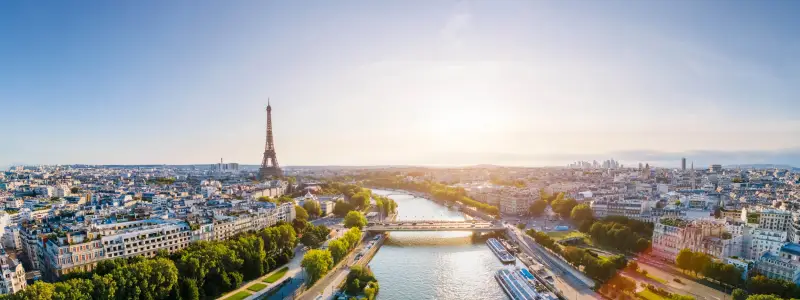 Paris aerial panorama with river Seine and Eiffel tower, France. Romantic summer holidays vacation destination. Panoramic view above historical Parisian buildings and landmarks with blue sky and sun