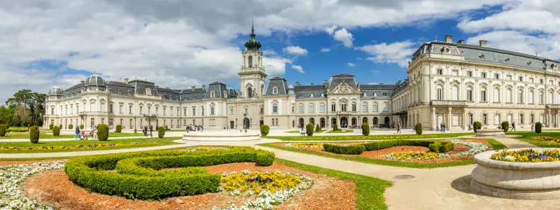 Keszthely, Beautiful Baroque Palace of the Festetics family (Helikon Palace Museum) Historical architecture in Hungary Panorama blue sky with picturesque clouds, spring gardens. Keszthely 30.04.2023